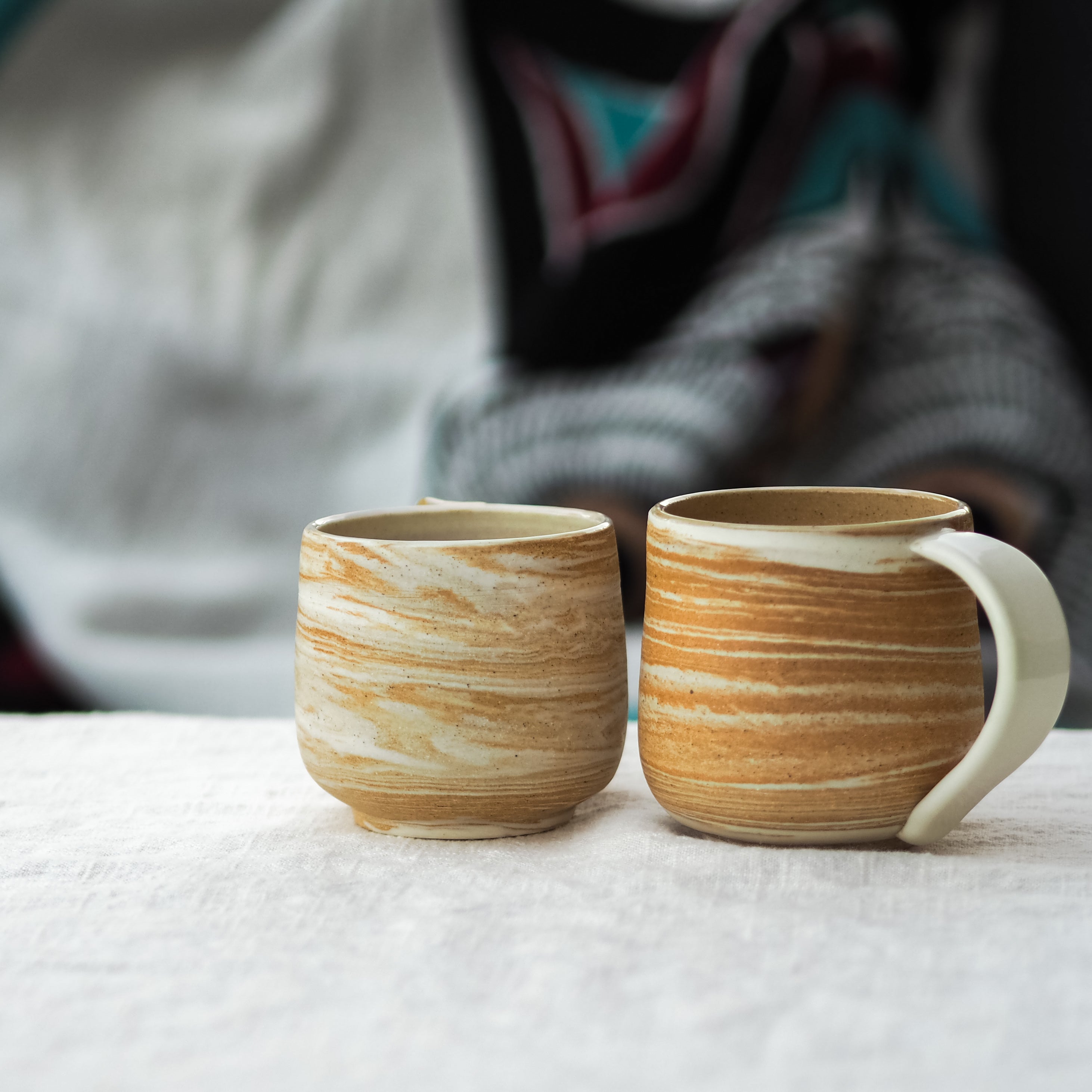 Two handmade ceramic mugs with layered stoneware and porcelain design, part of the landscapes mug collection by Veronica Smith Ceramics.