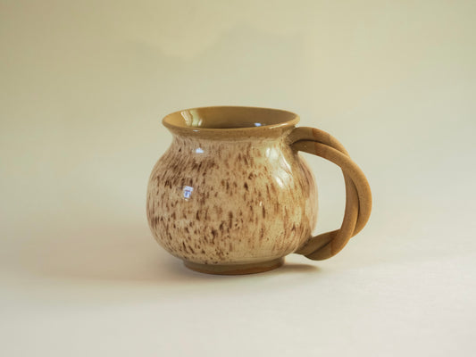 Handmade stoneware mug with a braided handle, soft white speckled glaze, inspired by traditional Talavera forms from Mexico.