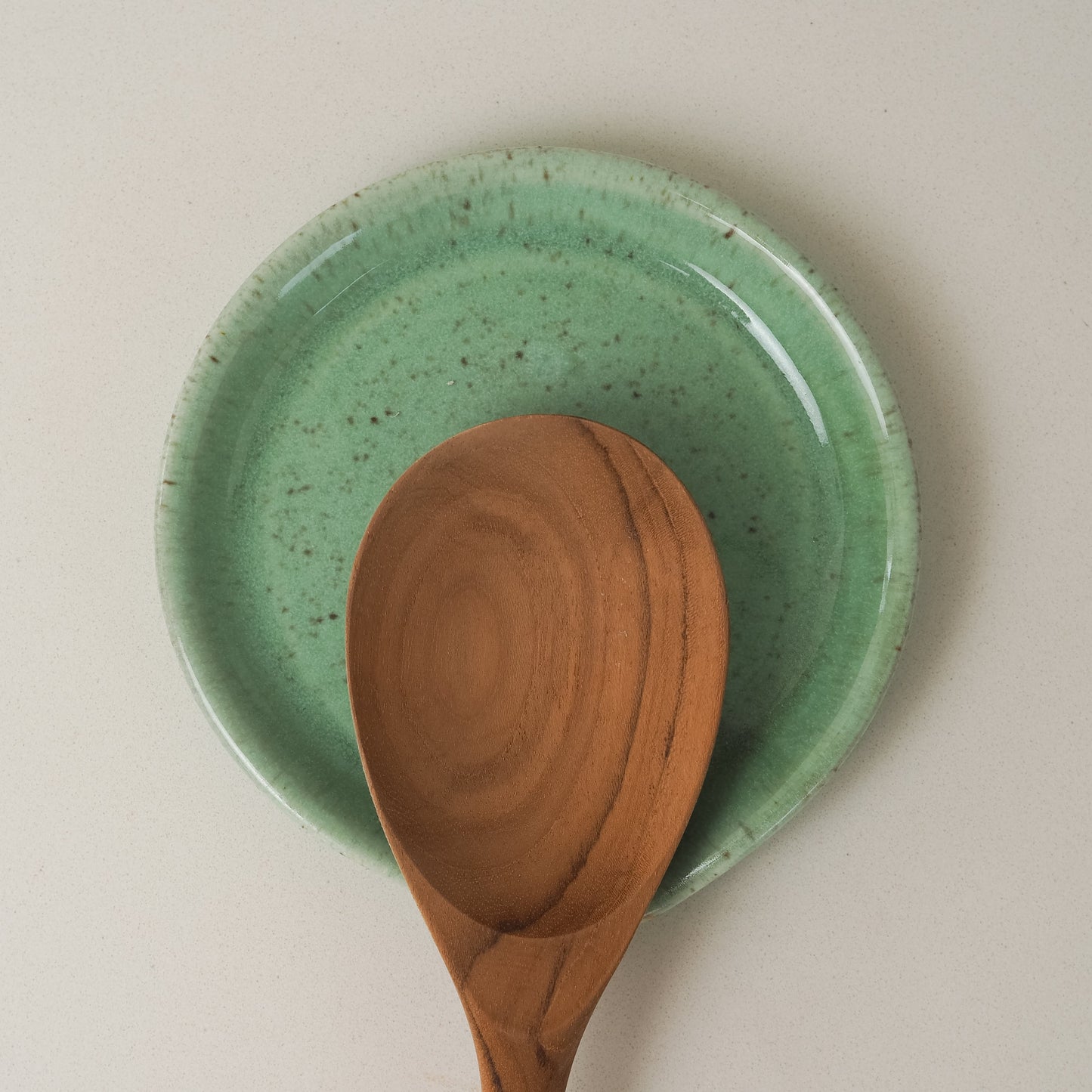 Green ceramic spoon rest with a wooden spoon 
