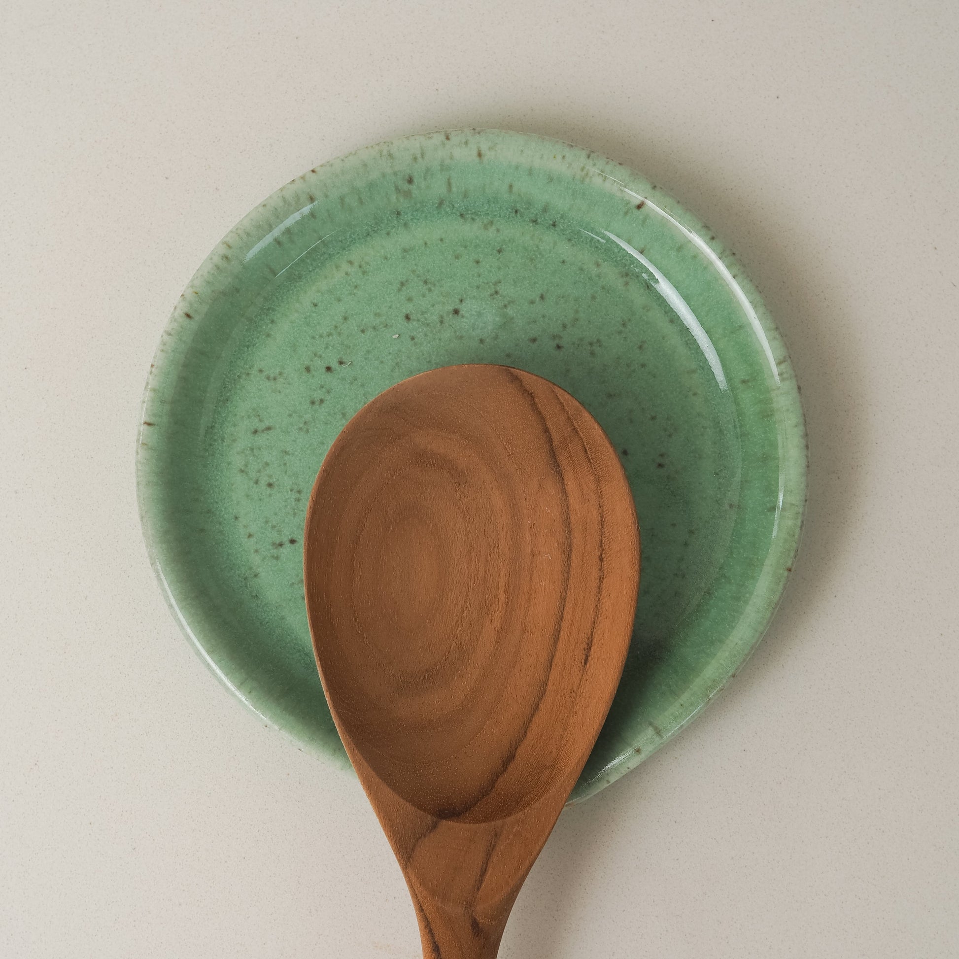 Green ceramic spoon rest with a wooden spoon 