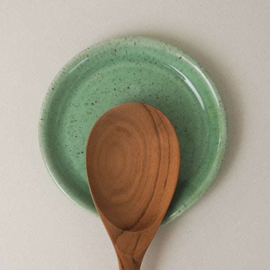 Green ceramic spoon rest with a wooden spoon 
